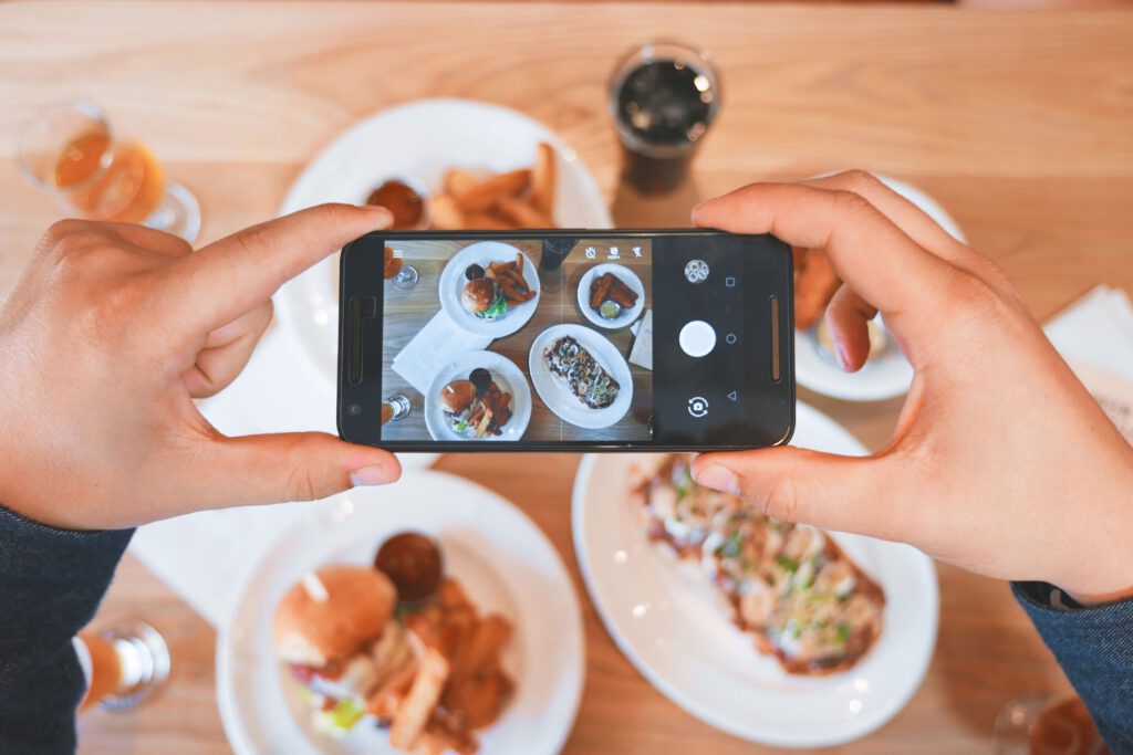 person taking a picture of food on their phone